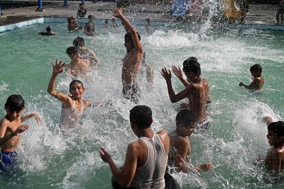 Un grupo de niños se refresca en una piscina en este día caluroso en Lahore, Pakistán. 