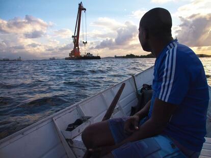 En Magé, un pueblo de pescadores a orillas de la bahía de Guanabara, los derrames no declarados de petróleo, las plantas de tratamiento de hidrocarburos y los cargueros amenazan la forma tradicional de vida. En la foto, 'O Pelé', un activista medioambiental, de espaldas, lucha para que la economía de pesca de la región siga activa. Denuncia que un compañero suyo ha sufrido seis atentados, dos de ellos bajo protección policial. Hablan de mafias, milicias a sueldo del petróleo que asesinan a los pescadores que se oponen a las empresas de hidrocarburos. Brasil es el país más peligroso para los activistas medioambientales, según un estudio reciente.