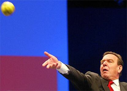 Schröder arroja una manzana a uno de los delegados del SPD durante la última sesión del congreso del partido.