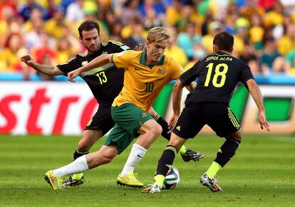 El jugador australiano Ben Halloran controla el bal&oacute;n entre Juan Mata (i) y Jordi Alba.