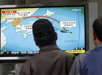 Varios ciudadanos surcoreanos ven la televisión la noticia sobre el lanzamiento de un cohete estratégico por parte de Corea del Norte