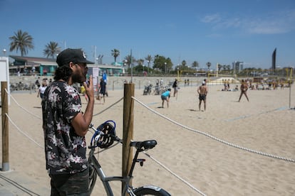 Un hombre fuma fuera de los límites de una playa sin tabaco, en Barcelona.