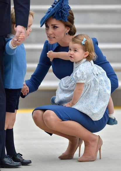 Kate Middleton con su hija en brazos, habla con su hijo.
