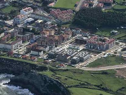 A la derecha, primeras construcciones de la macrourbanización La Talá, casi a pie de acantilado, en el municipio de Llanes, donde se van a construir hasta 500 nuevas viviendas: desde chalés de una planta, en la zona más cercana al mar y edificios de tres alturas en la parte más alejada.