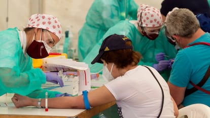 Personal sanitario extrae sangre en un test de covid en Torrejón de Ardoz en Madrid, en mayo.