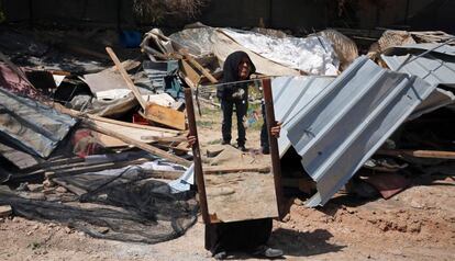 Una mujer beduina recupera un espejo de su casa demolida por fuerzas israelíes.