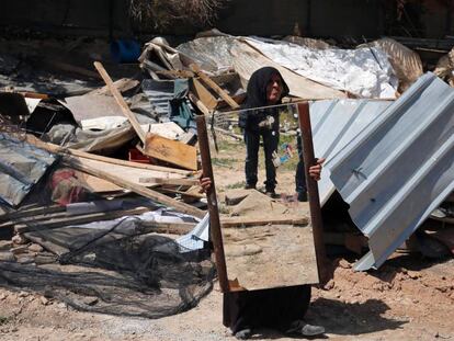 Una mujer beduina recupera un espejo de su casa demolida por fuerzas israel&iacute;es.