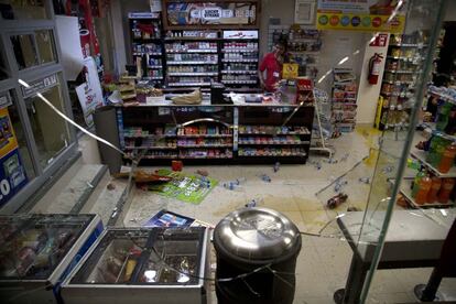 Un trabajador de una tienda de conveniencia, después de que algunos manifestantes irrumpieran al final de la marcha en el establecimiento destrozando todo lo que vieron.