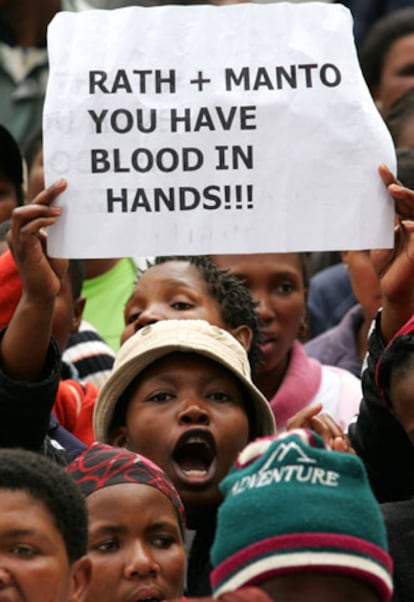 Activistas de la Campaña Acción y Tratamiento (TAC) se manifiestan en Ciudad del Cabo el pasado viernes. En el cartel se lee: "Rath [el médico alemán] + Manto [ministra de Sanidad] tenéis las manos manchadas de sangre".