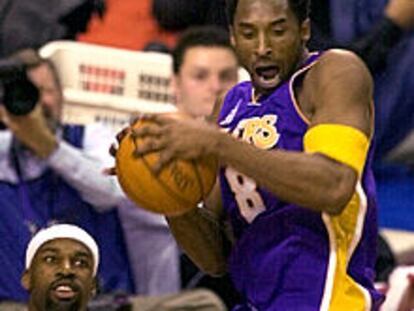 Kobe Bryant consigue un rebote ante la mirada de Baron Davis.