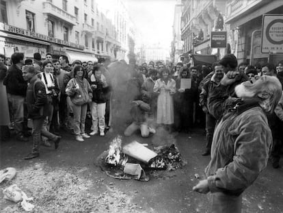 Un grupo de personas observa la quema de una papelera en Madrid durante la huelga general del 14 de diciembre de 1988.