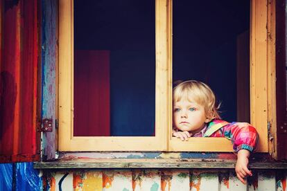 Un niño mira por la ventana. 