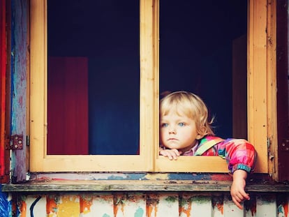 Un niño mira por la ventana. 