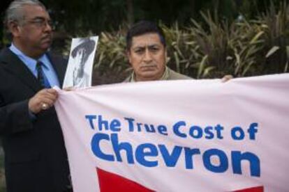 Fotografía cedida por Amazon Watch de Sergio Curipoma (d), campesino y representante de los más de 30.000 afectados por las acciones de la petrolera en Ecuador, quien se manifiesta junto a activistas medioambientales y otros afectados por la contaminación de la Amazonía ecuatoriana por parte de la petrolera estadounidense Chevron. EFE/Caroline Bennett/Amazon Watch