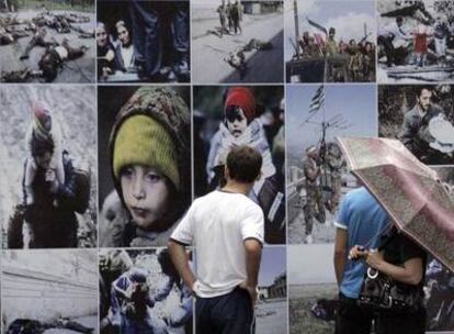 Un grupo de personas observa el mural fotográfico colocado en el centro de Tbilisi realizado con imágenes del conflicto que el año pasado enfrentó a Georgia con Rusia.
