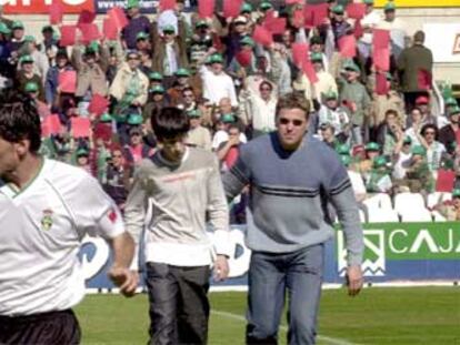 Aficionados del Racing muestran una tarjeta roja a Piterman al inicio del partido.