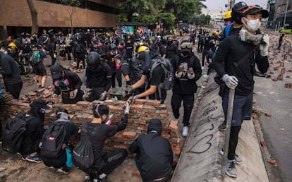 Manifestantes construyen este jueves un muro de ladrillo para cortar una calle junto a la Universidad Politécnica de Hong Kong.