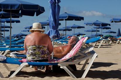 Una pareja toma el sol en la playa de Benidorm.