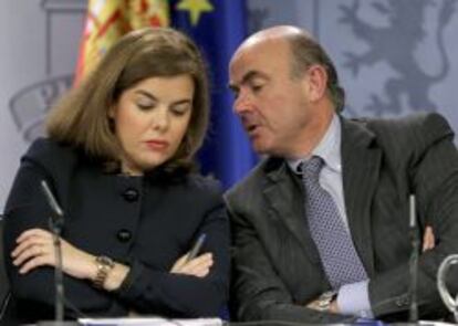 La vicepresidenta del Gobierno, Soraya Sáenz de Santamaría (i), junto al ministro de Economía, Luis de Guindos