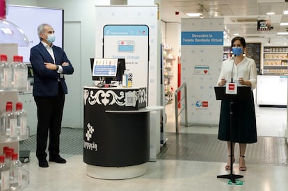 La presidenta de la Comunidad de Madrid Isabel Díaz Ayuso presenta la Tarjeta Sanitaria Virtual, acompañada por el consejero de Sanidad del Gobierno regional Enrique Ruiz Escudero, este lunes, en una farmacia madrileña.