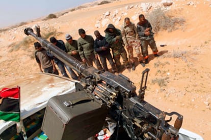 Miembros de las fuerzas rebeldes se detienen a rezar en la carretera que conduce hacia Sirte, en un punto a unos 120 kilómetros de la cuna de Muamar el Gadafi.