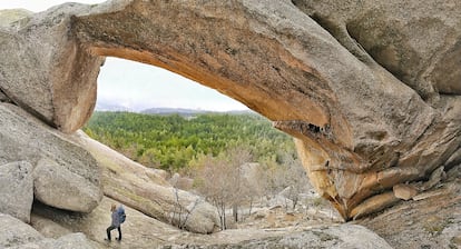 Puente de Los Poyos: no es Namibia, es la Pedriza (Manzanares el Real, Comunidad de Madrid). Se podría haber comparado este arco natural con alguno de los más de 2.000 que hay en el parque nacional de los Arcos, en Utah (EE UU), pero aquellos son de frágil arenisca y este de duro granito. El Puente de Los Poyos se parece más a The Bridge, el arco de granito rosado que permite contemplar a través de su ojo el macizo de Spitzkoppe, en Namibia, que también hace las delicias de los senderistas y los escaladores, como este madrileño. Idénticos, idénticos, no son. El vano del africano tiene una anchura de 27 metros y el del español, 40. Y hasta aquel se llega casi en coche —solo hay que andar unos 50 metros—, mientras que para admirar el Puente de Los Poyos no queda otra que caminar tres horas y media. Eso es, más o menos, lo que se tarda en recorrer la ruta circular de 9,5 kilómetros. Por el camino tampoco veremos damanes roqueros —unos lejanos parientes de los elefantes similares a cobayas gigantes o marmotas—, sino cabras montesas.