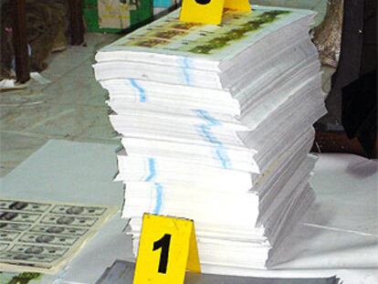 Planchas para imprimir los billetes y montones de billetes falsificados.