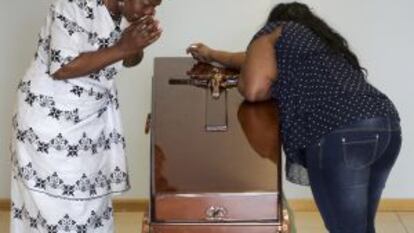 The mother of Samba, Clementine Nijba (l), weeps next to the coffin of her daughter.