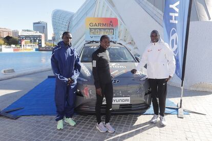 Los corredores de élite Cherono, Kamworor y Tuitoek, en la Ciudad de las Artes de Valencia, con el coche eléctrico guía del maratón.