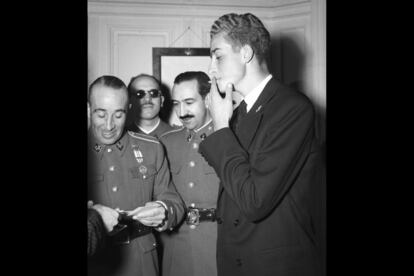 El príncipe Juan Carlos de Borbón fuma un cigarrillo acompañado de algunos de sus profesores. De izquierda a derecha: el comandante de Caballería Nicolás Cotoner; el de Infantería, Marqués de Valenzuela y el de Artillería, Alfonso Armada.