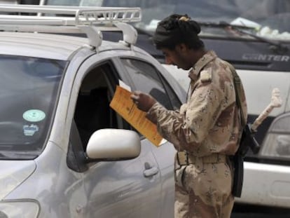 Un soldado yemen&iacute; inspecciona la documentaci&oacute;n en un puesto de control.