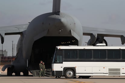 Una aeronave militar espera a migrantes que abordan un autobús en Fort Bliss, El Paso, Texas, el jueves 30 de enero de 2025.