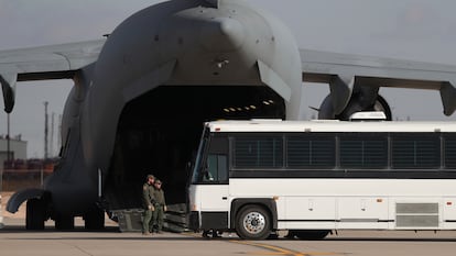 Una aeronave militar espera a migrantes que abordan un autobús en Fort Bliss, El Paso, Texas, el jueves 30 de enero de 2025.