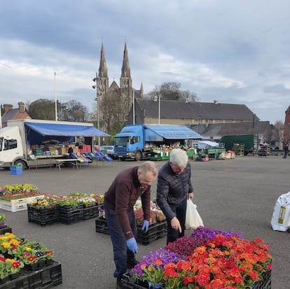 Kevin (izquierda) ordena sus flores en el Mercado de Shambles, en Armagh. Al fondo, la catedral católica de San Patricio.
