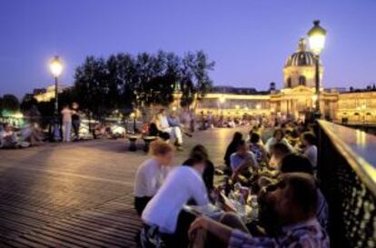 O concorrido Pont des Arts, em Paris, ao anoitecer.