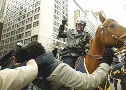 Un policía montado golpea a un manifestante mientras otro le sujeta, cerca de la ONU en Nueva York.