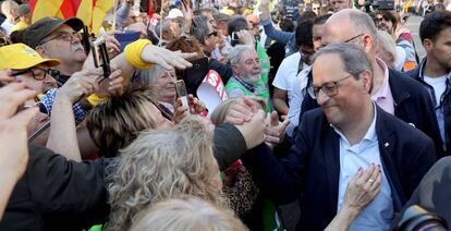 El presidente de la Generalitat, Quim Torra, (derecha), saluda a asistentes de la manifestaci&oacute;n este s&aacute;bado en Madrid. 