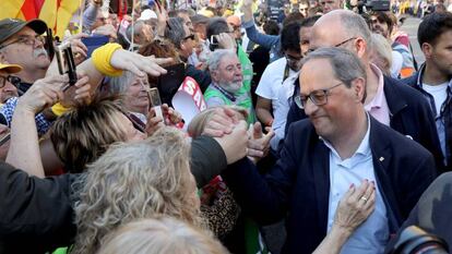 El presidente de la Generalitat, Quim Torra, (derecha), saluda a asistentes de la manifestaci&oacute;n este s&aacute;bado en Madrid. 