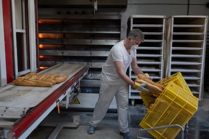 Raúl Jiménez, panadero de Pan Almajano, coloca los panes después de salir del horno.