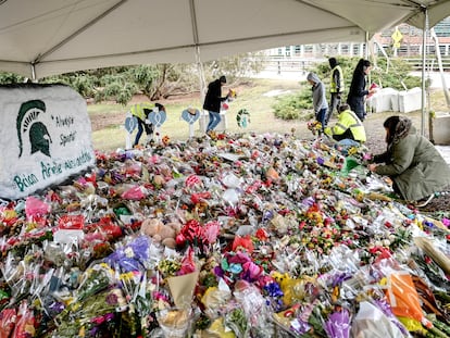 People work to remove flowers from the memorial at the Rock in honor of three students killed at Michigan State University on March 2, 2023, in East Lansing, Michigan.