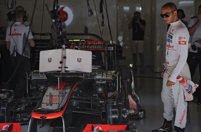 Lewis Hamilton observa su monoplaza en el garaje de McLaren.