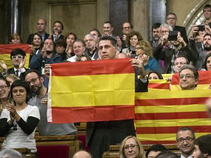 PP deputies hold up Spanish and Catalan flags after the vote.