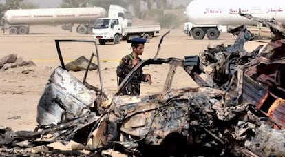 Un militar yemen&iacute; observa los restos del coche de los turistas espa&ntilde;oles.