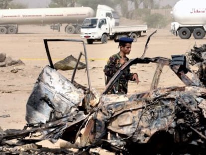 Un militar yemen&iacute; observa los restos del coche de los turistas espa&ntilde;oles.