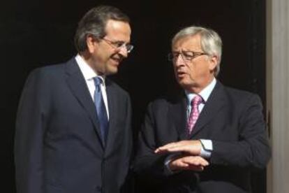 El primer ministro de Grecia, Antonis Samaras (i), da la bienvenida al presidente del Eurogrupo, Jean Claude Juncker (d), durante su encuentro ayer en  Atenas, Grecia.