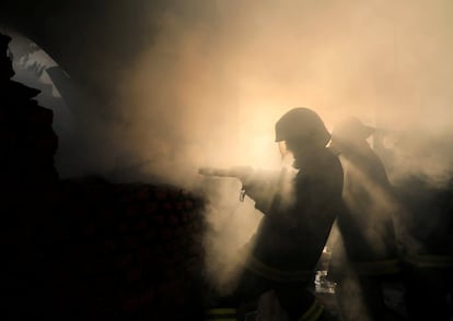 Los bomberos trabajan para apagar un incendio en un almacén en Katmandú (Nepal).