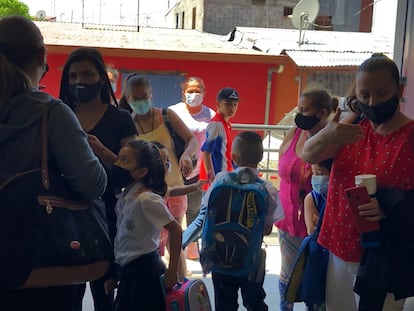 La maestra Cindy Morales (de rojo), de quinto grado, acompaña a sus alumnos a la salida de la escuela La Carpio, en donde la totalidad de los estudiantes acuden a las clases presenciales los días en que les corresponde, a pesar de la opción que dio el Ministerio de Educación a los padres de familia de no enviar a sus hijos a las aulas por el riesgo sanitario.