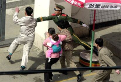 Un policía chino intenta impedir la entrada de unos norcoreanos en el consulado japonés en Shenyang (noreste de China).