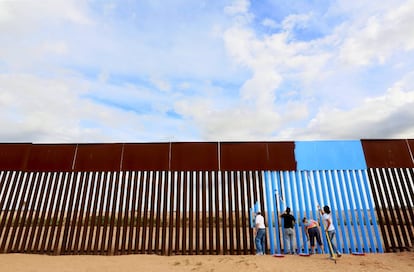 Voluntarios de Erasing the Border pintan la barrera entre EE UU y México para hacerla 'invisible'.