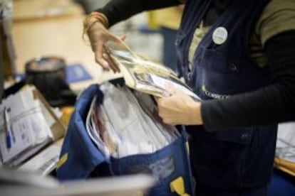 A mail service employee prepares a cart for a delivery round.